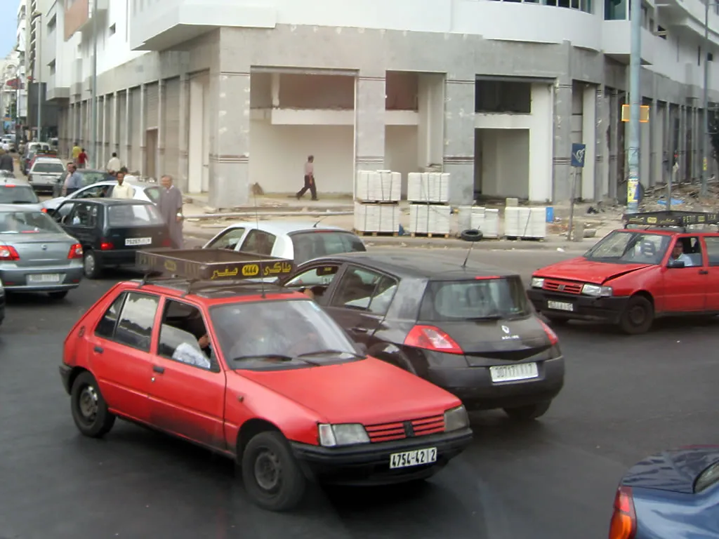 Deux petits taxis rouges circulant à Casablanca