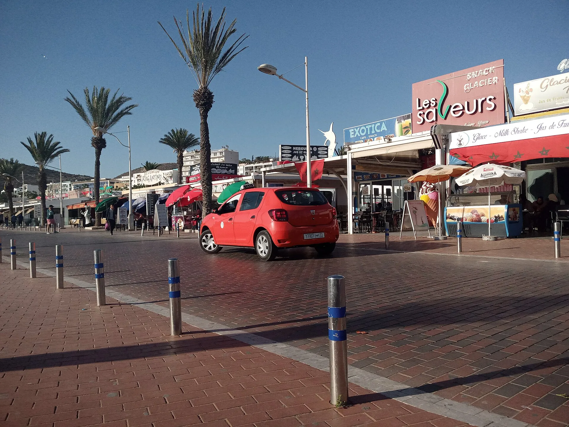 Petit taxi rouge circulant dans une ville marocaine